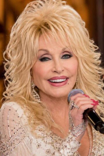 Dolly Parton smiling with a microphone