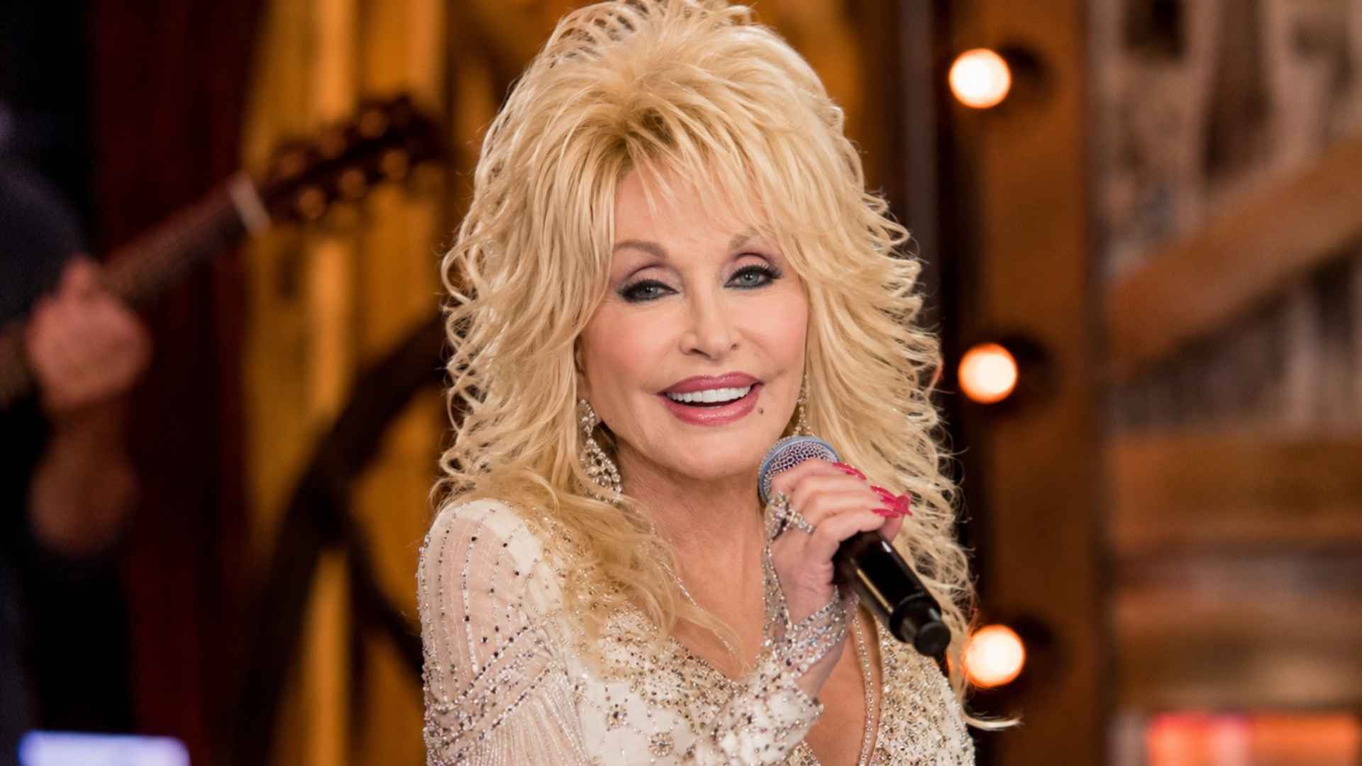 Dolly Parton smiling with a microphone