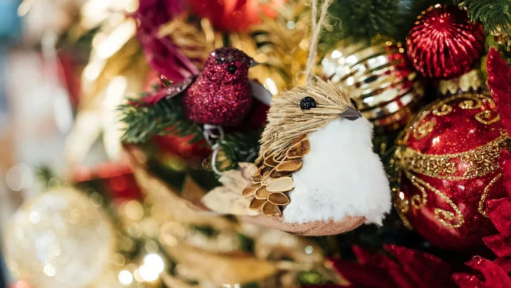 Colorful ornaments hanging from evergreen Christmas tree branches
