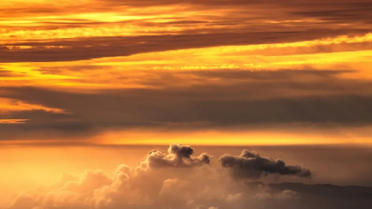 Glowing sunset clouds representing later evening daylight by the clock
