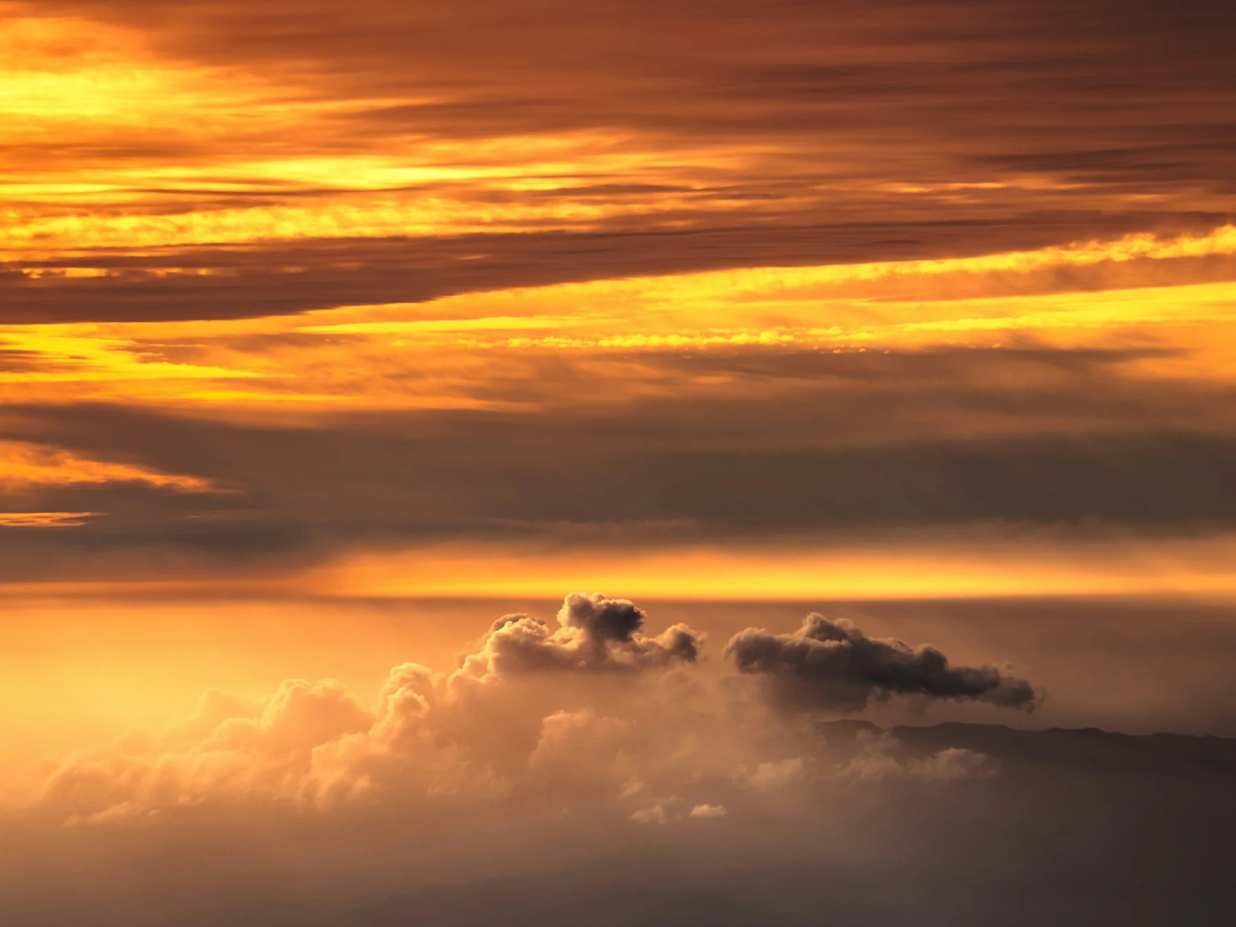 Cloud layers glowing orange and gold at sunset