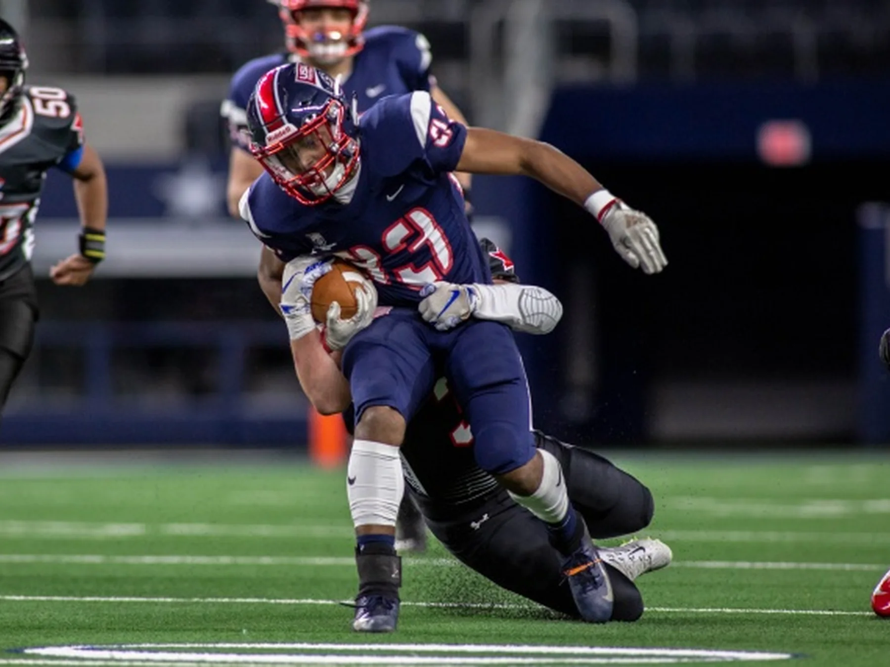 Ball carrier being tackled during an American football game
