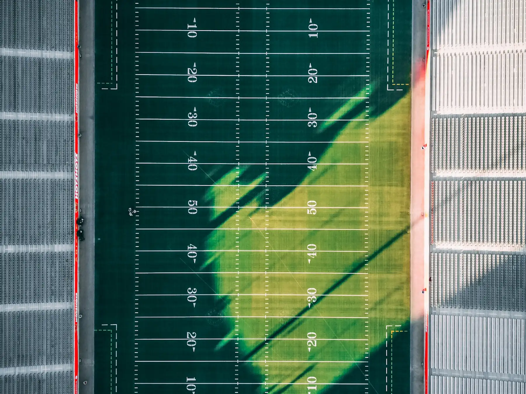 Aerial view of a green American football field marked with yard lines
