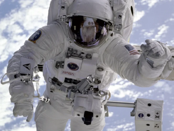 Astronaut performing a spacewalk above Earth