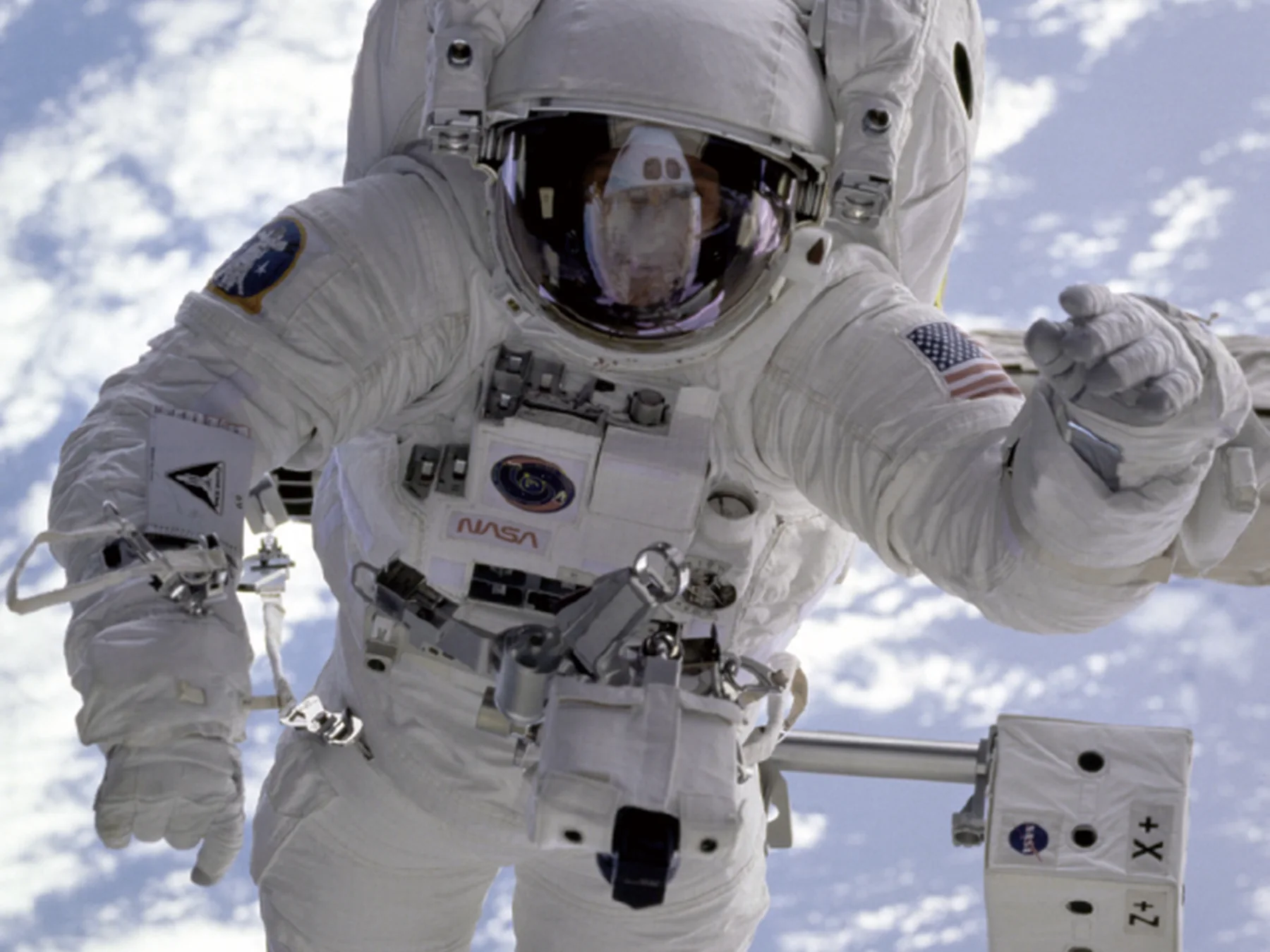 Astronaut performing a spacewalk above Earth
