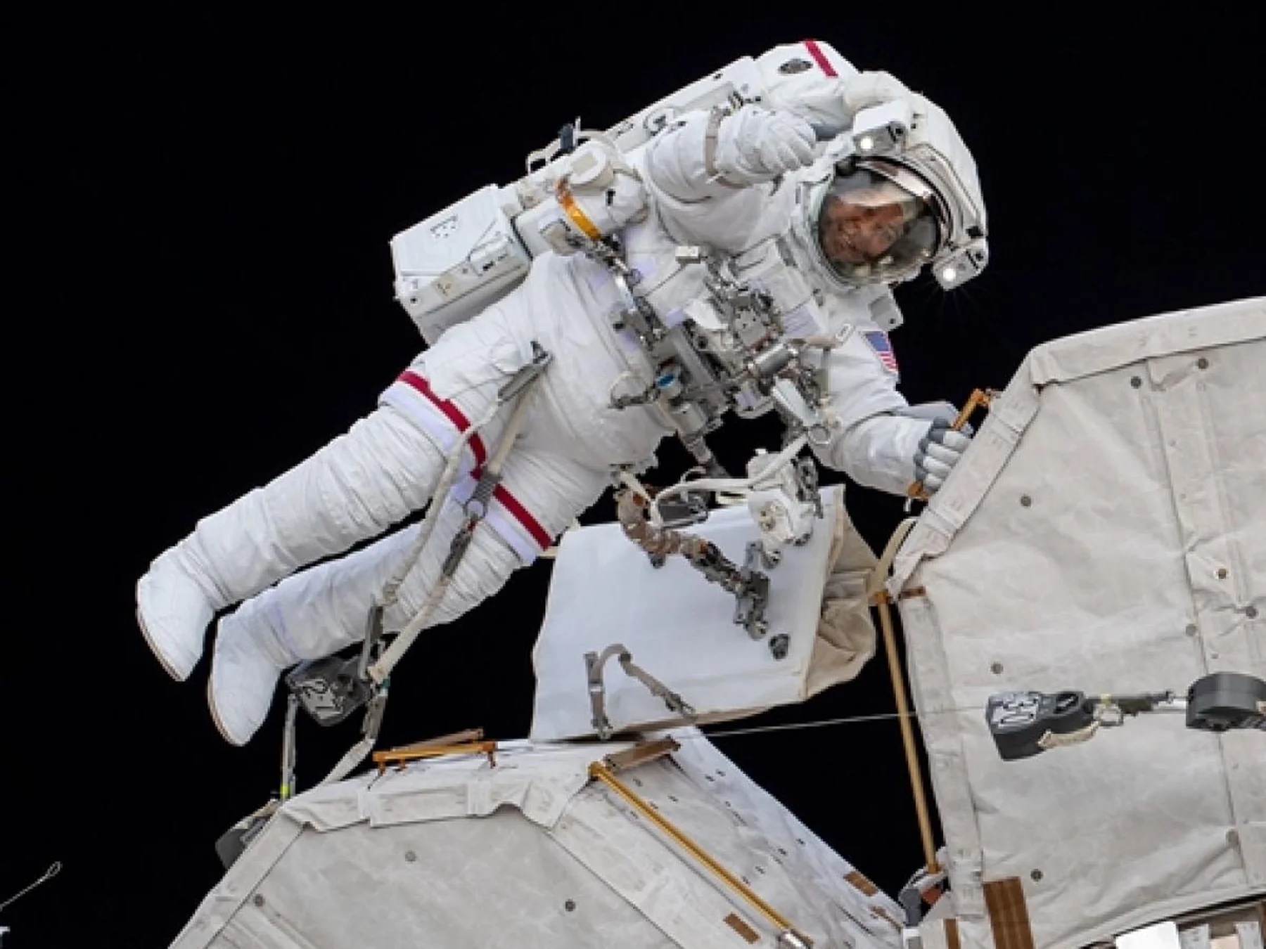 Astronaut floating outside a spacecraft during a spacewalk