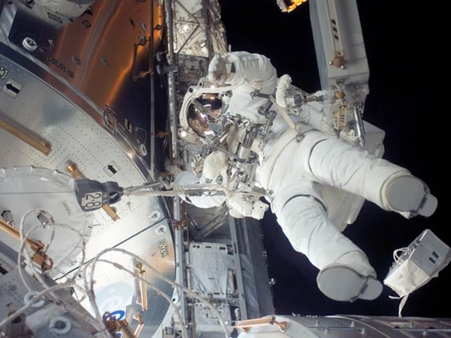Two astronauts working outside a spacecraft