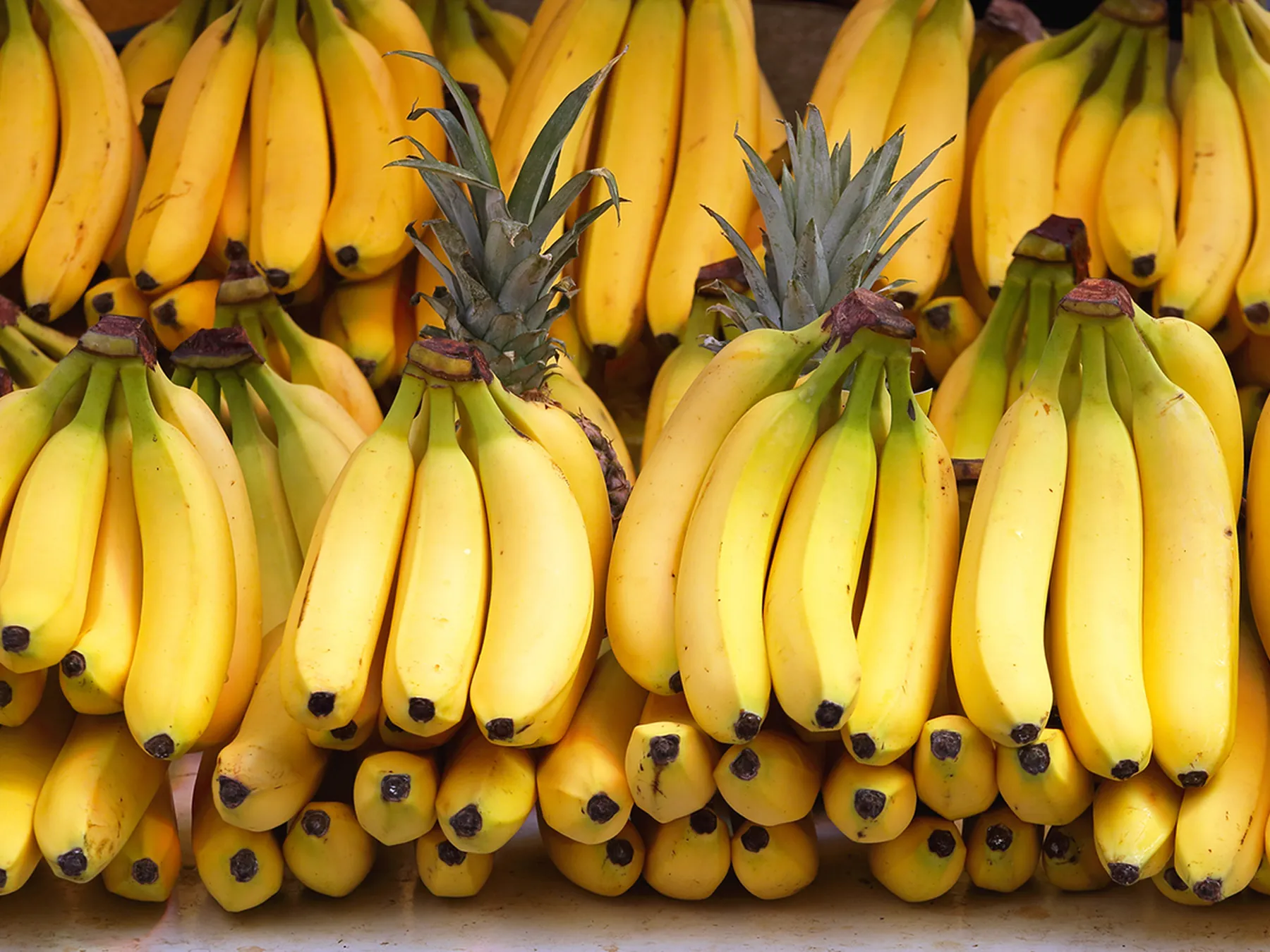 Display of ripe yellow banana bunches at a produce market