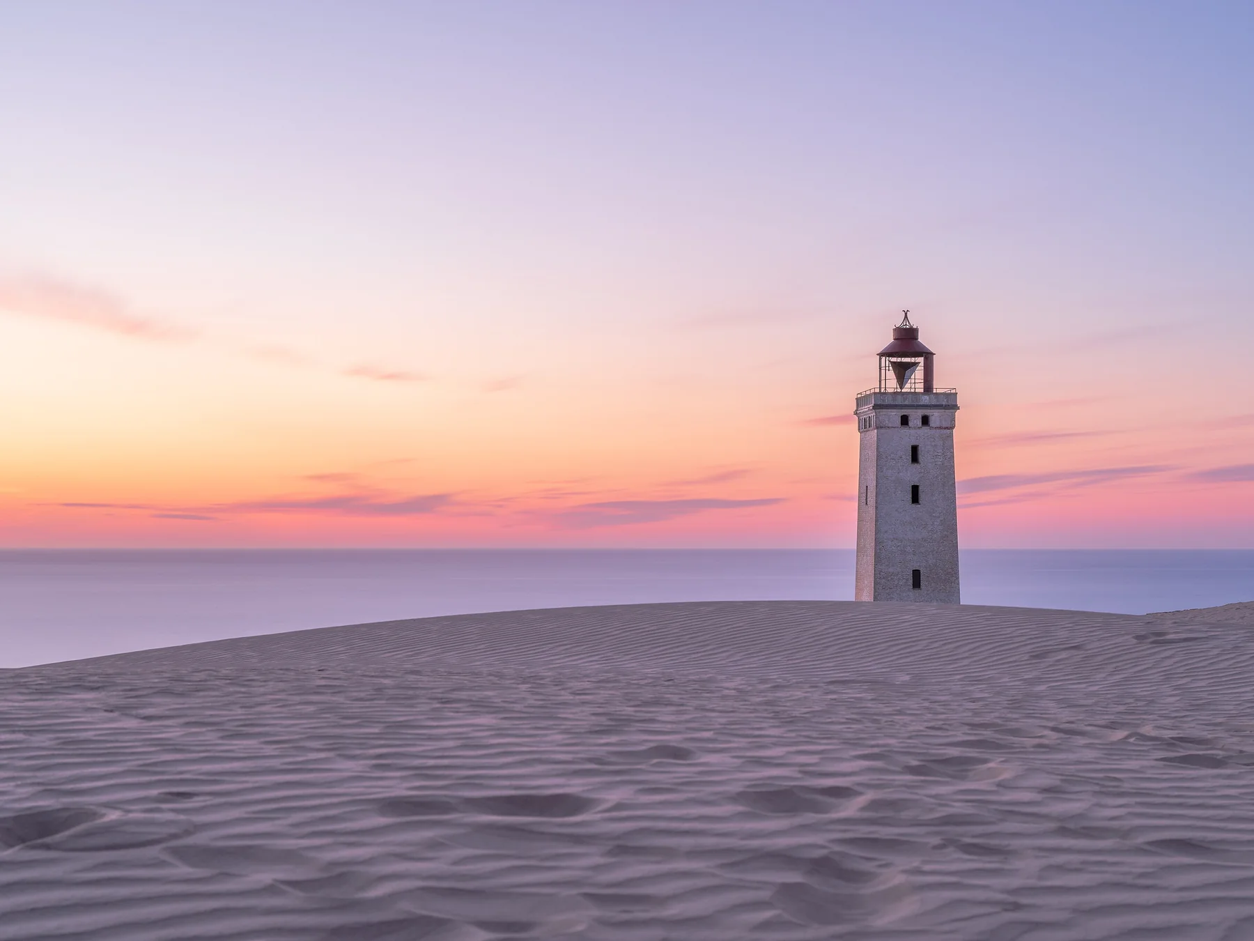 White lighthouse on the Danish coast at sunset