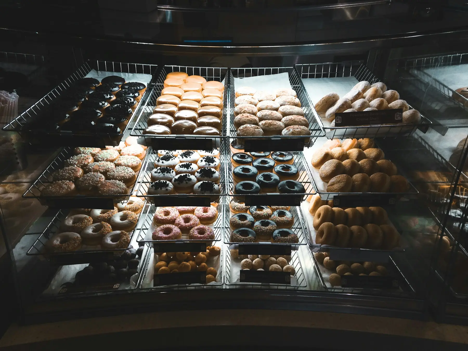 Rows of assorted doughnuts in a bakery display