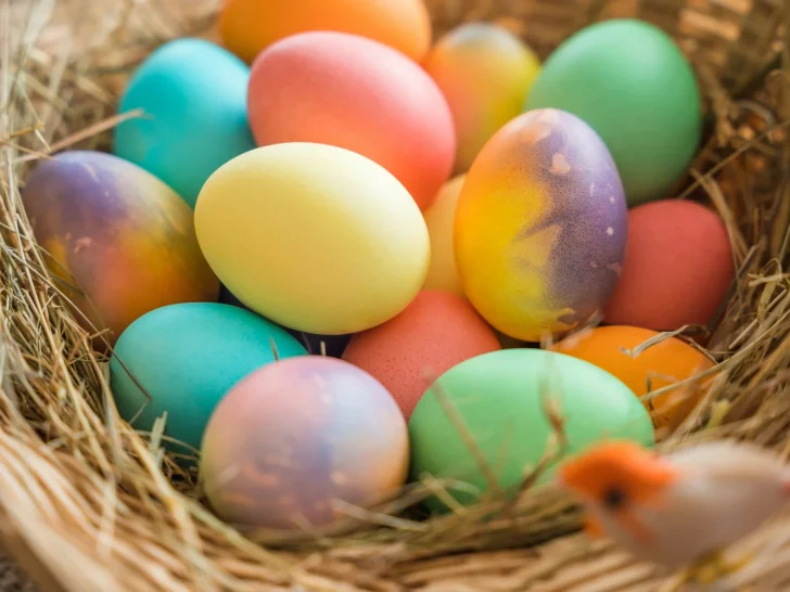 Basket filled with colorful painted Easter eggs nestled in straw