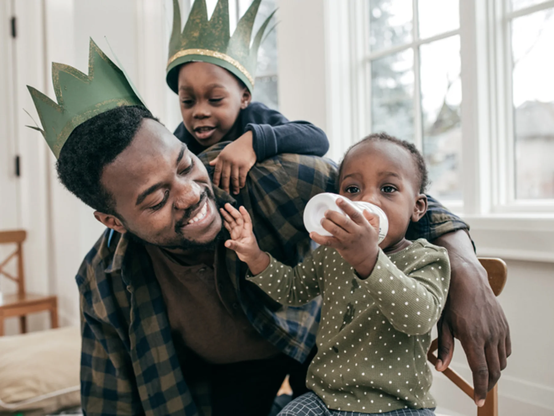 Father playing at home with his young children