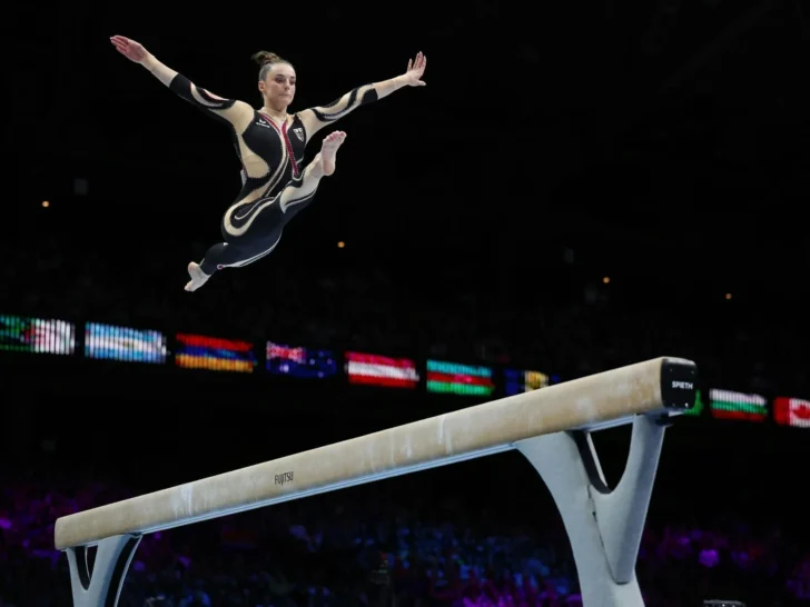 Gymnast performing above a balance beam