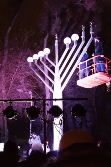 Large illuminated Hanukkah menorah during a public nighttime celebration
