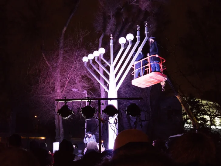 Large illuminated Hanukkah menorah during a public nighttime celebration