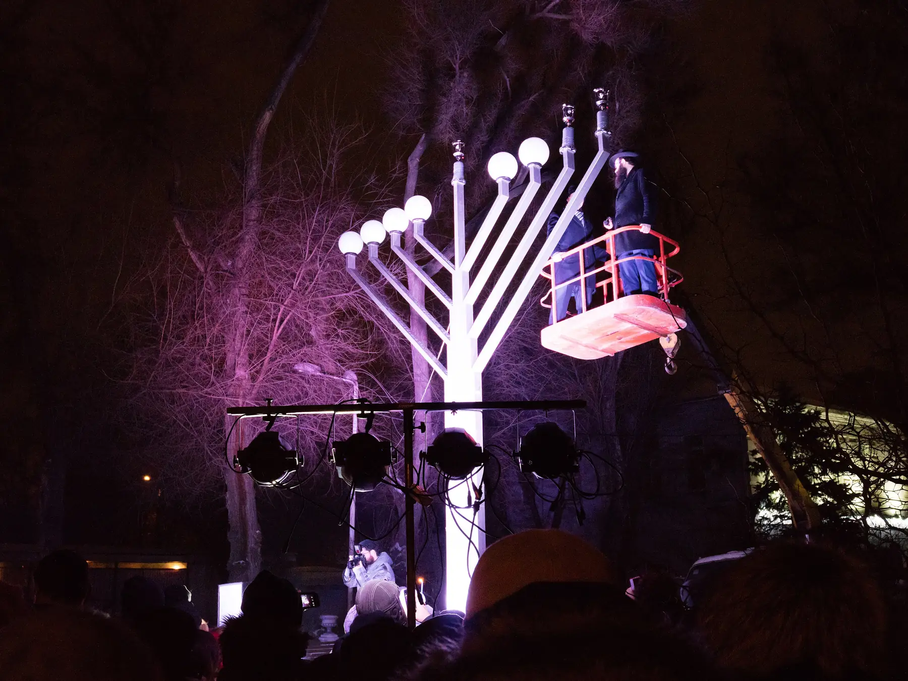 Large illuminated Hanukkah menorah during a public nighttime celebration
