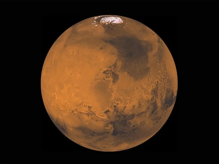 Full-disk view of Mars showing its rust-colored surface and polar ice cap