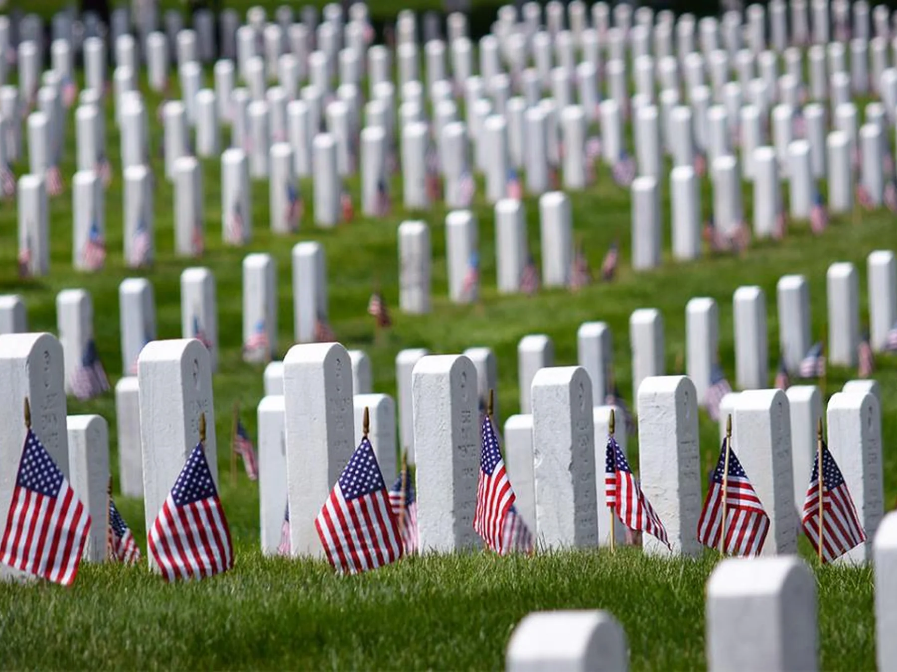 Gravestones decorated with American flags for Memorial Day