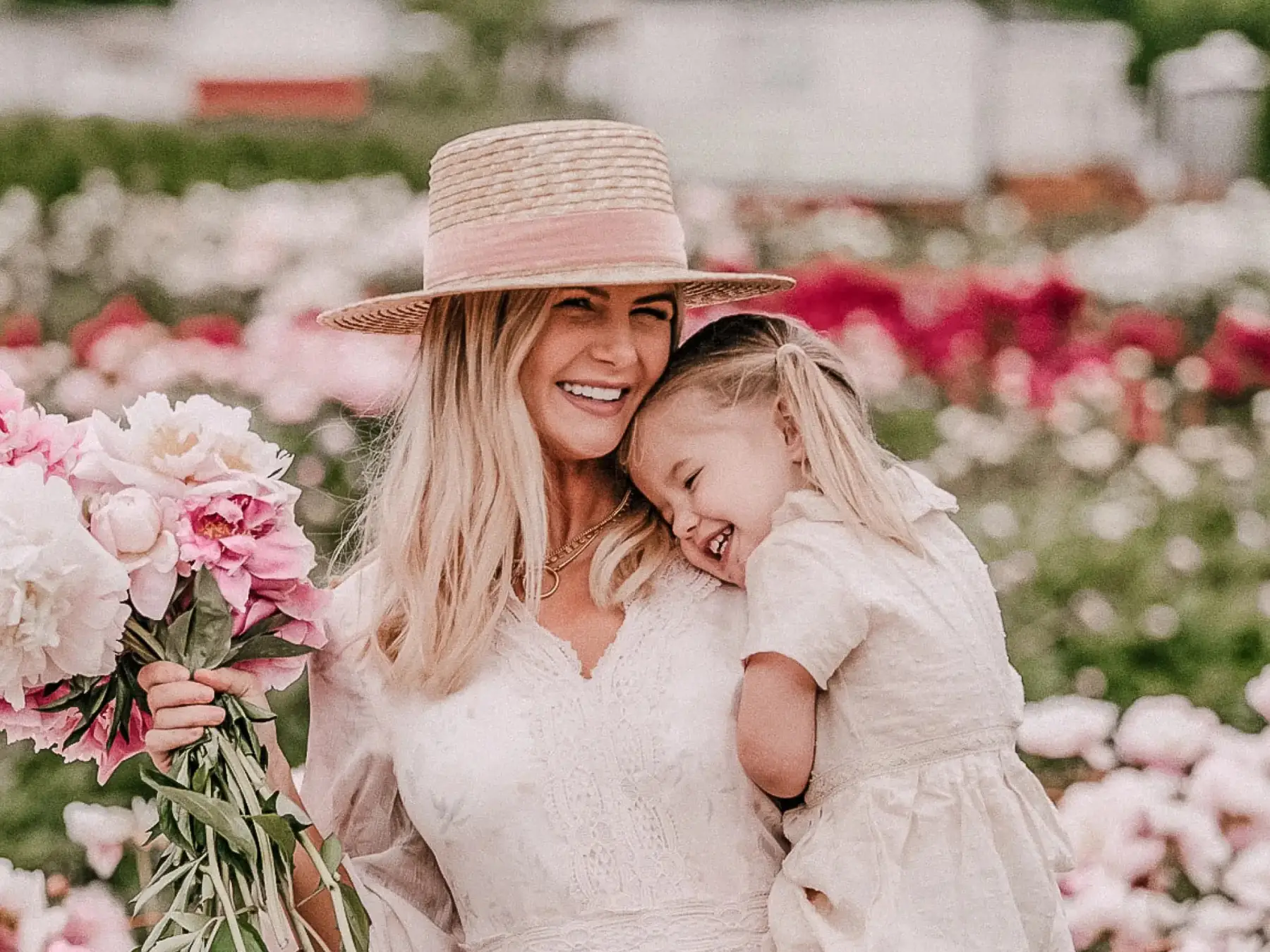 Mother and young daughter embracing among flowers