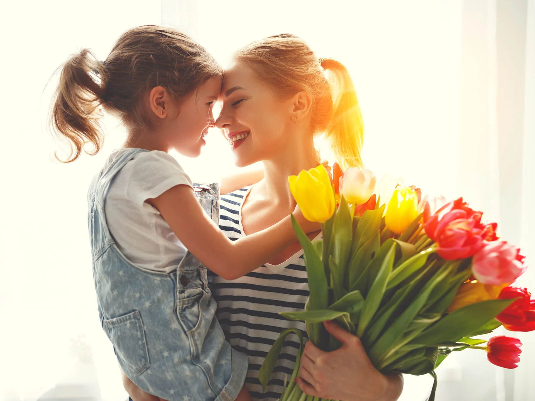 Mother and daughter sharing flowers at home