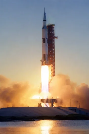NASA Saturn V rocket lifting off from a launch pad at dawn
