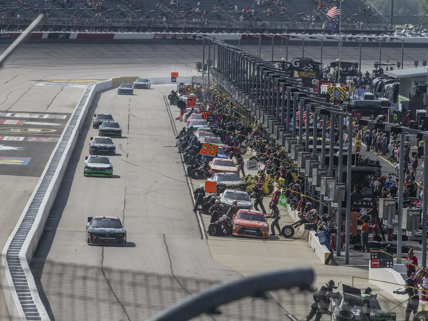 NASCAR race cars lined up along pit road