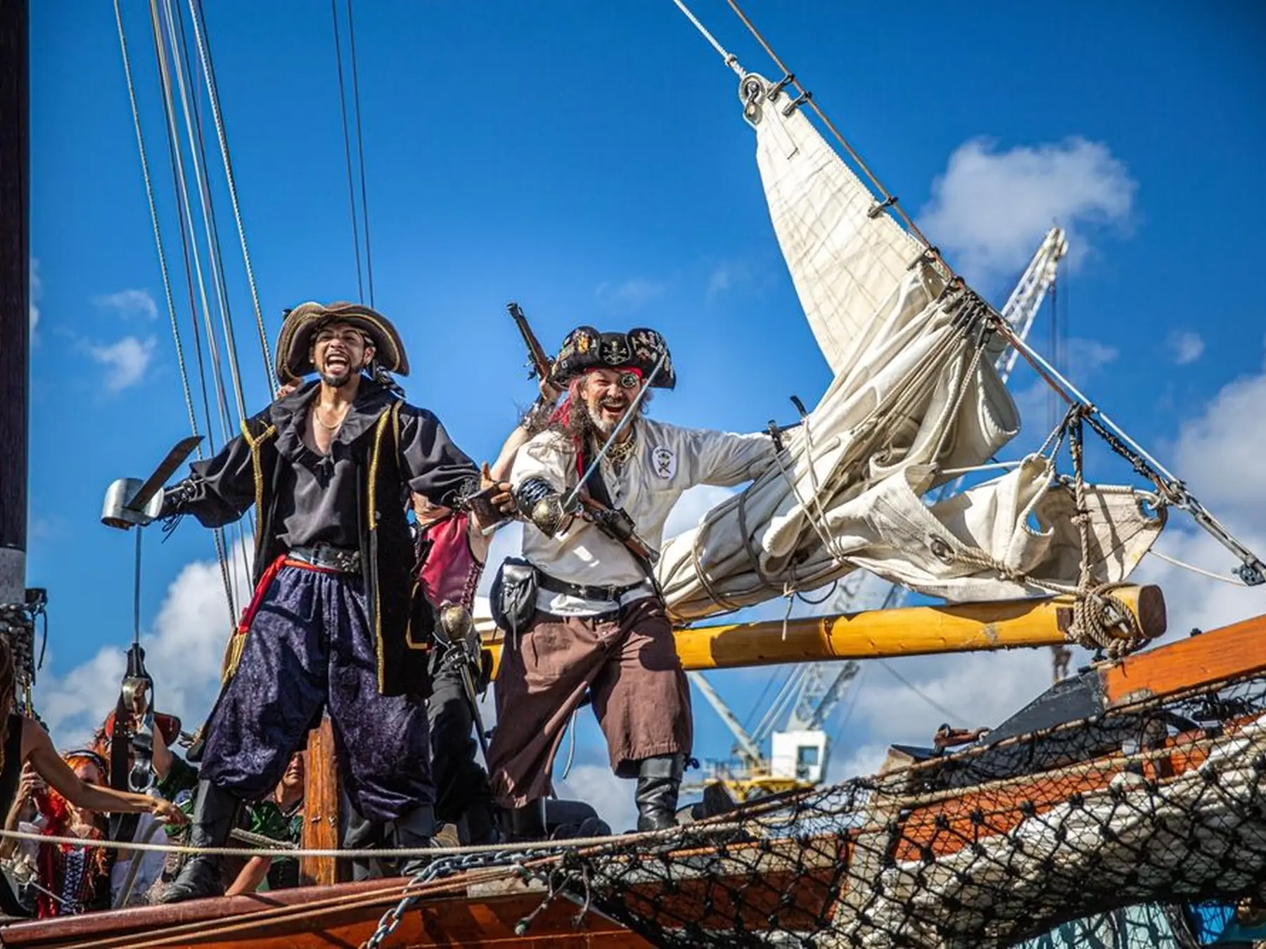 Pirate reenactors in costume aboard a sailing ship