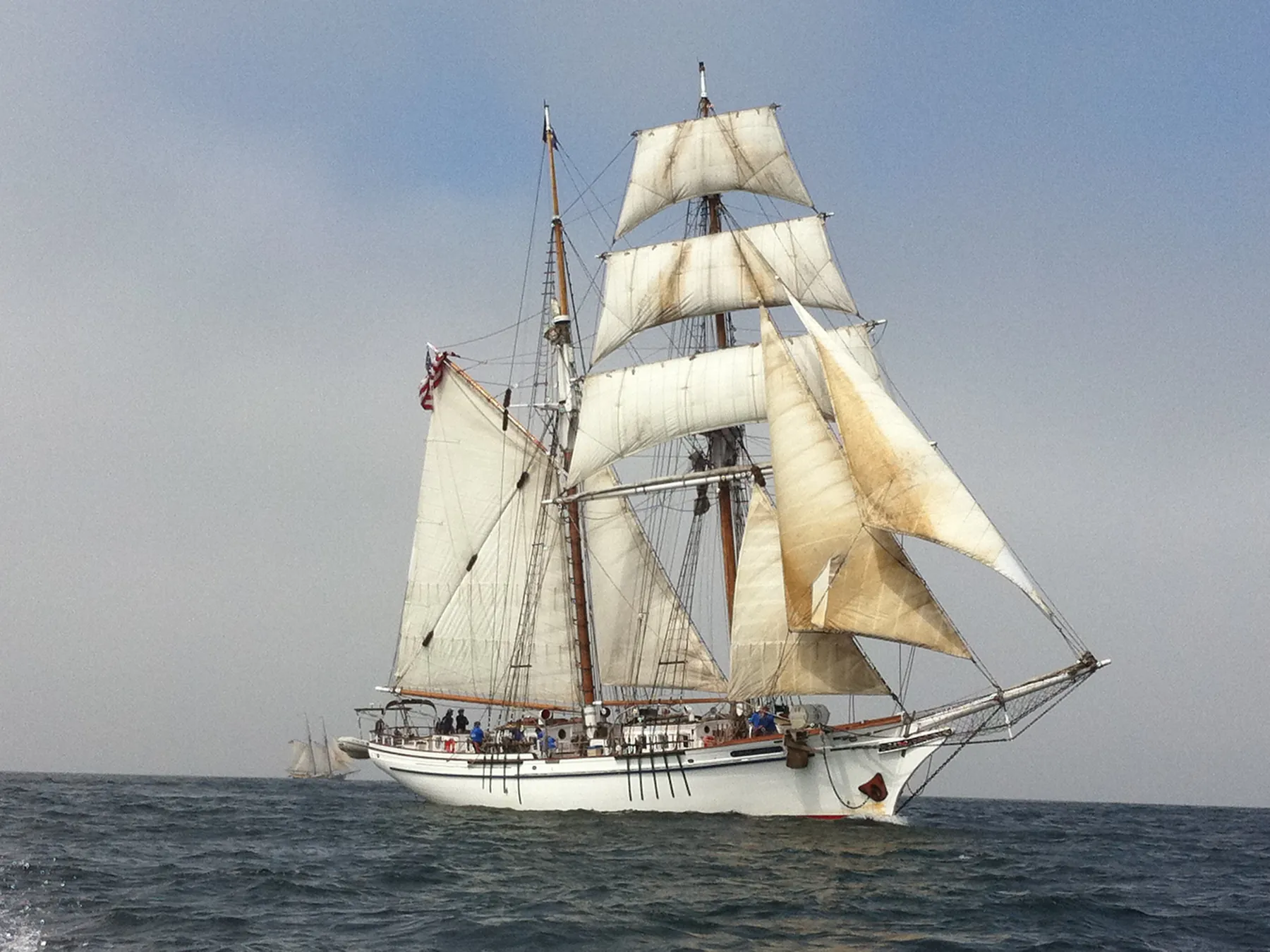 Tall sailing ship with white sails on the open sea