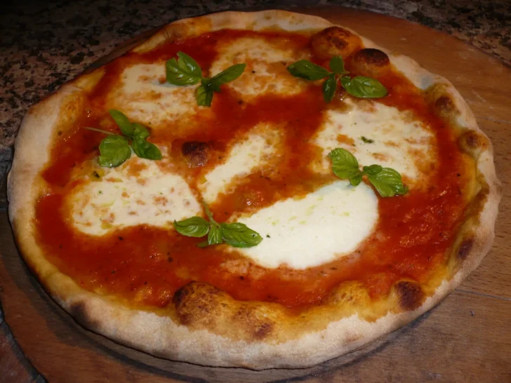 Margherita pizza topped with mozzarella, tomato sauce, and basil