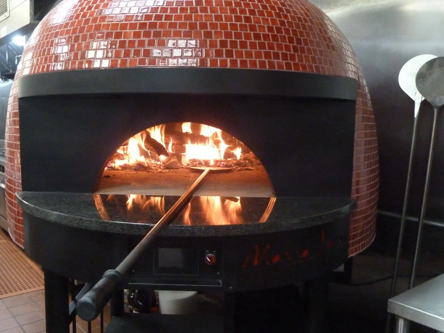 Wood-fired pizza oven with an active flame