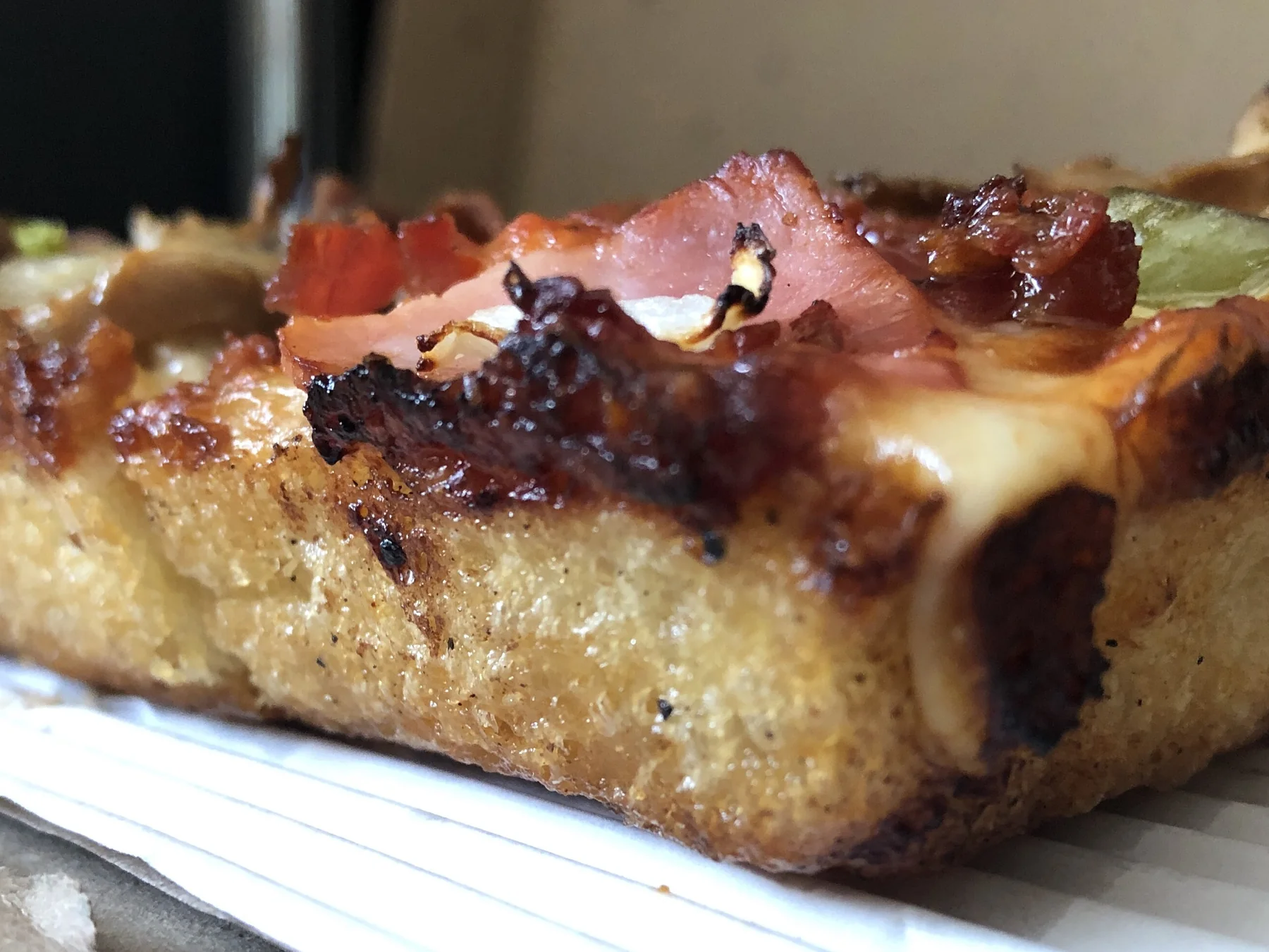 Close-up of a thick Detroit-style pizza slice
