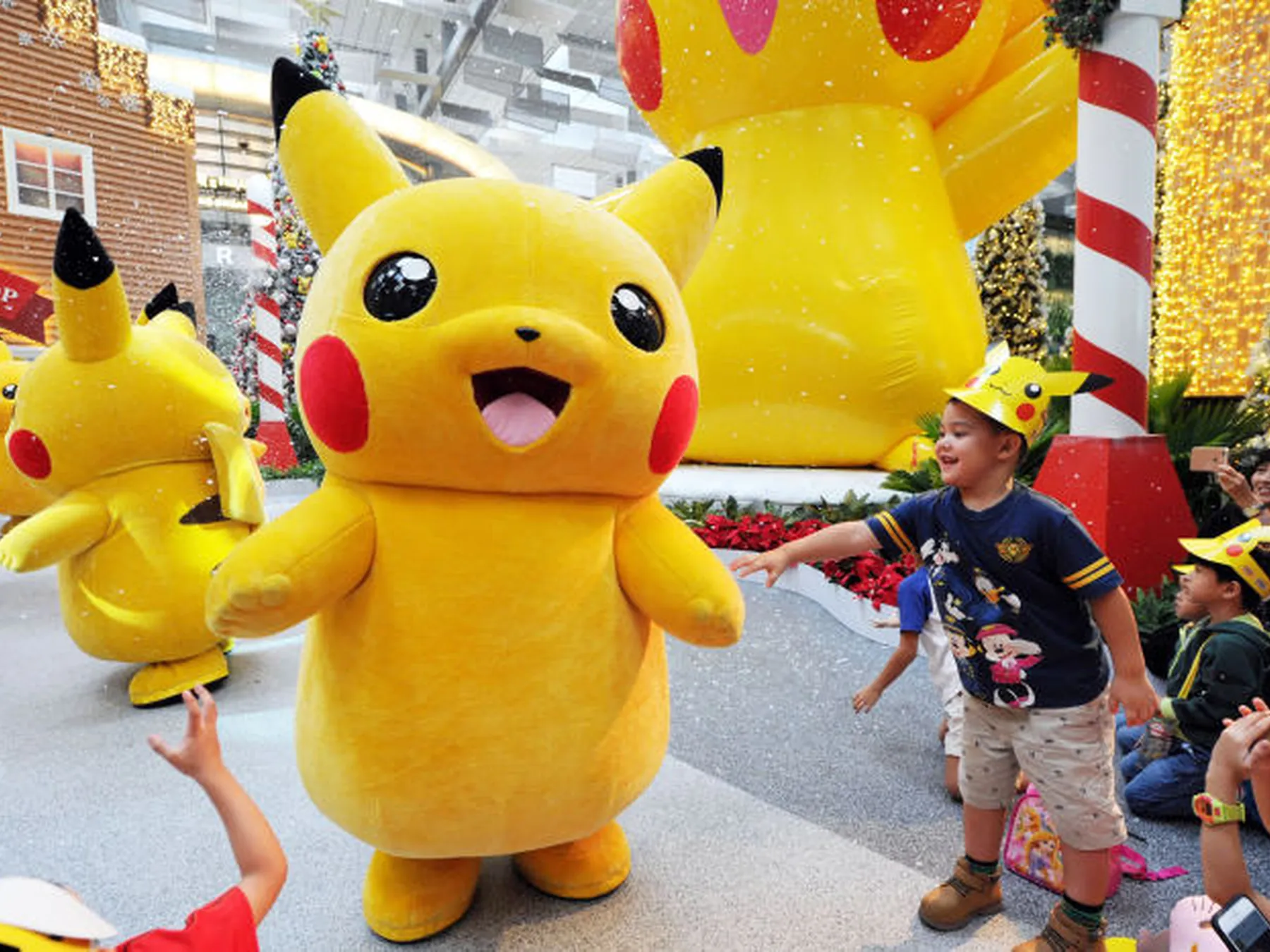 Pikachu mascot greeting a child at an event