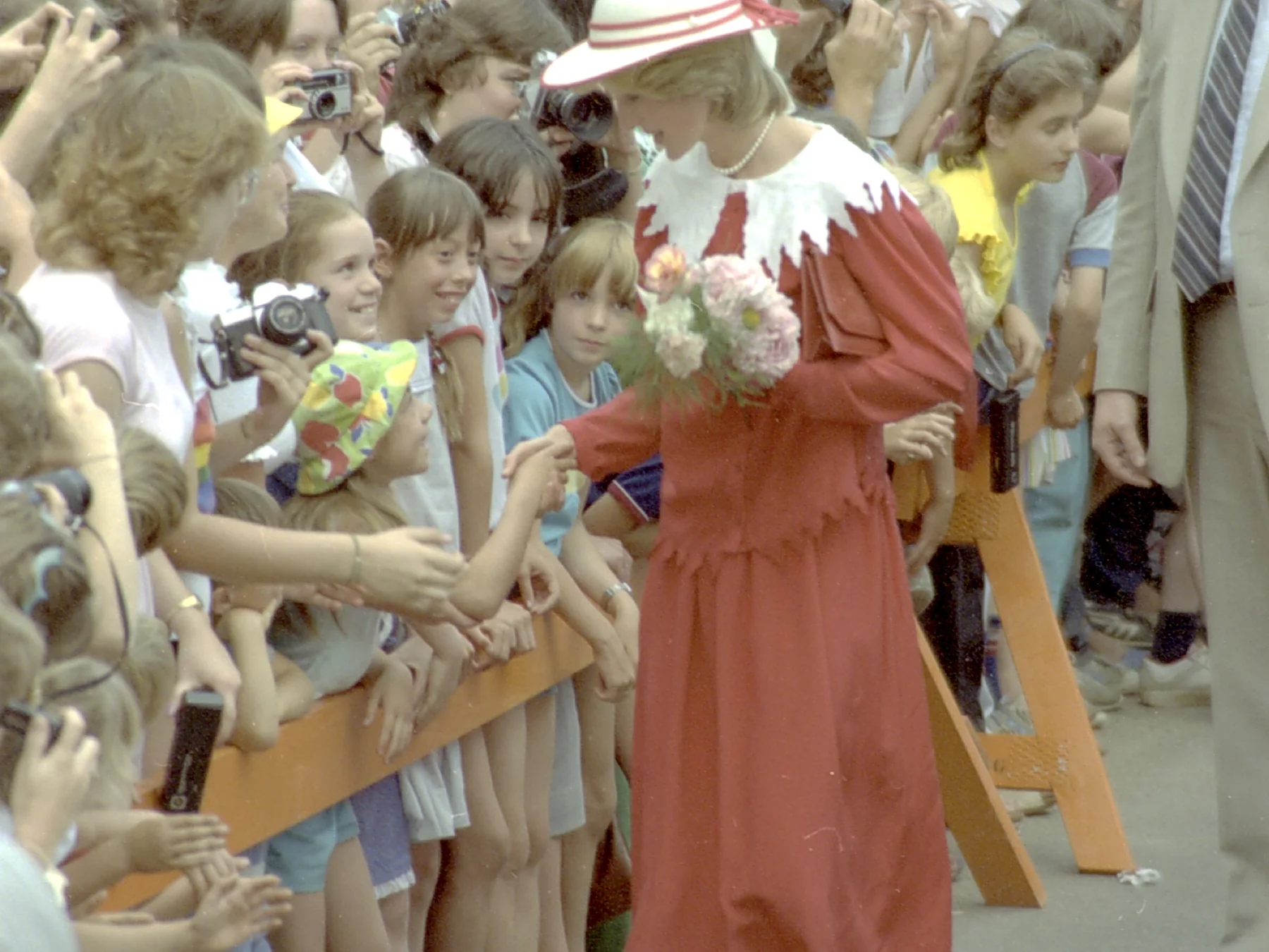 Princess Diana greeting children and receiving flowers