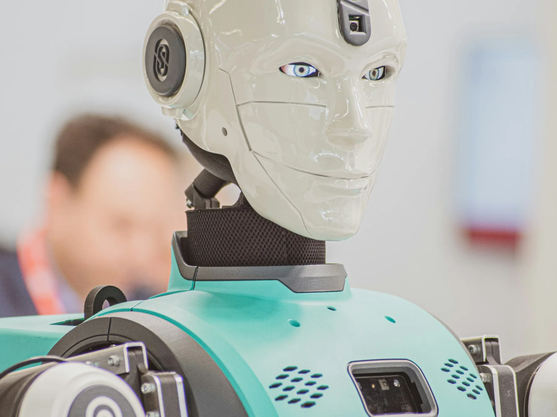 White humanoid robot with lifelike eyes at a technology exhibition