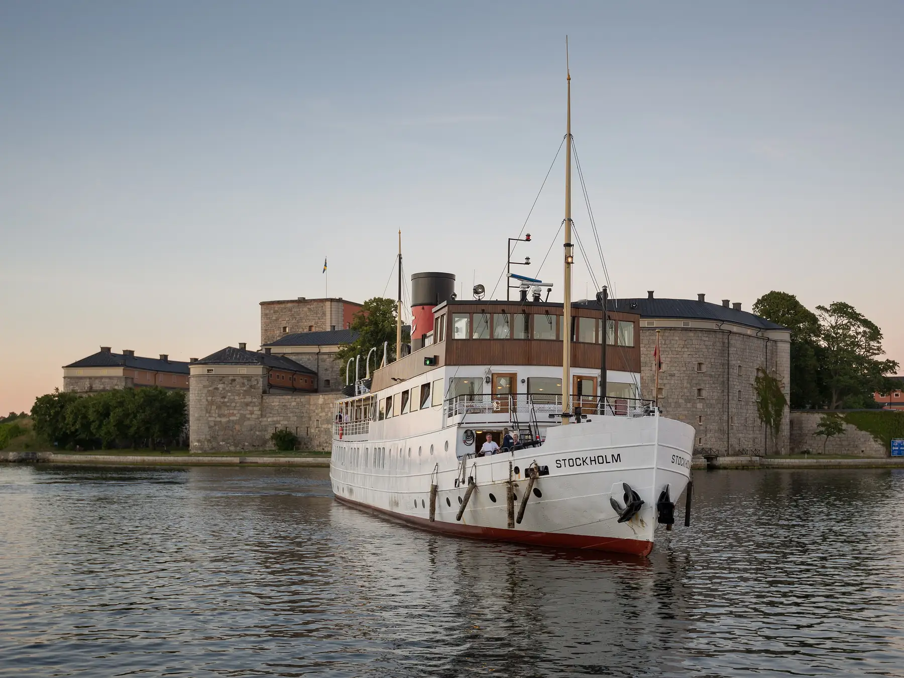 Passenger ferry sailing beside a historic fortress in Stockholm, Sweden