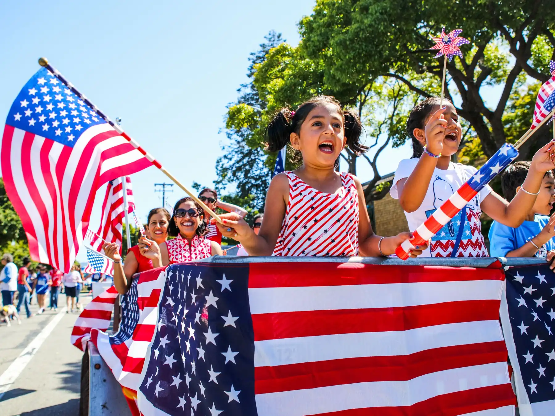 Children celebrating at a Fourth of July parade with American flags