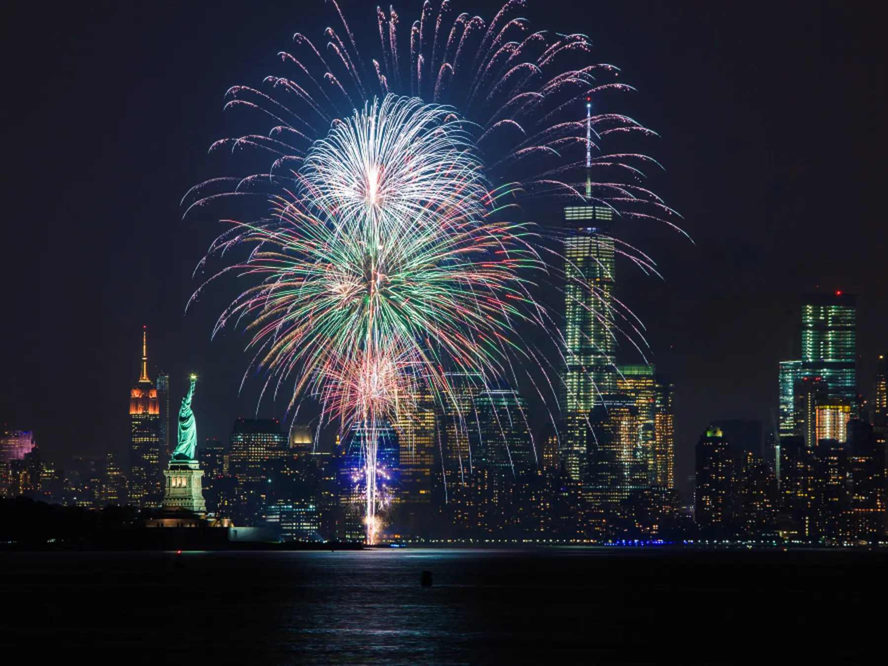 Fourth of July fireworks over the New York skyline and Statue of Liberty