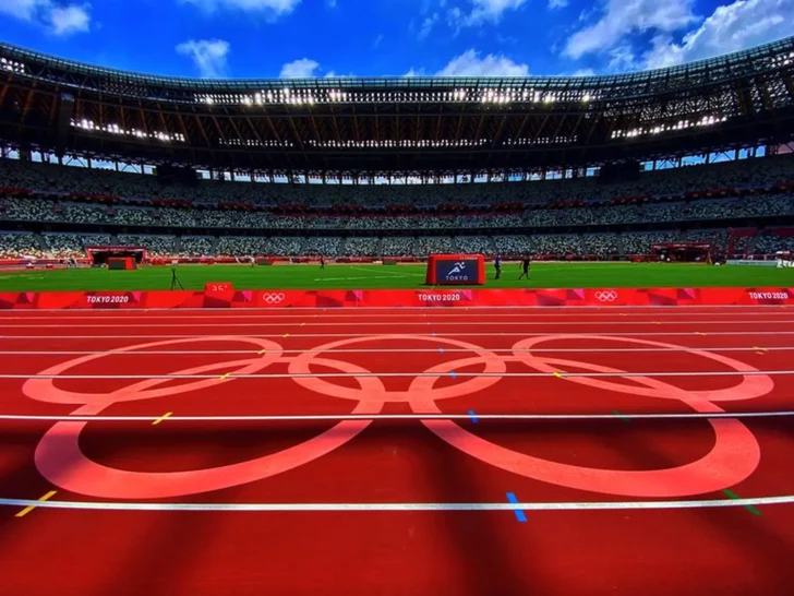 Olympic rings painted across the running track inside a stadium