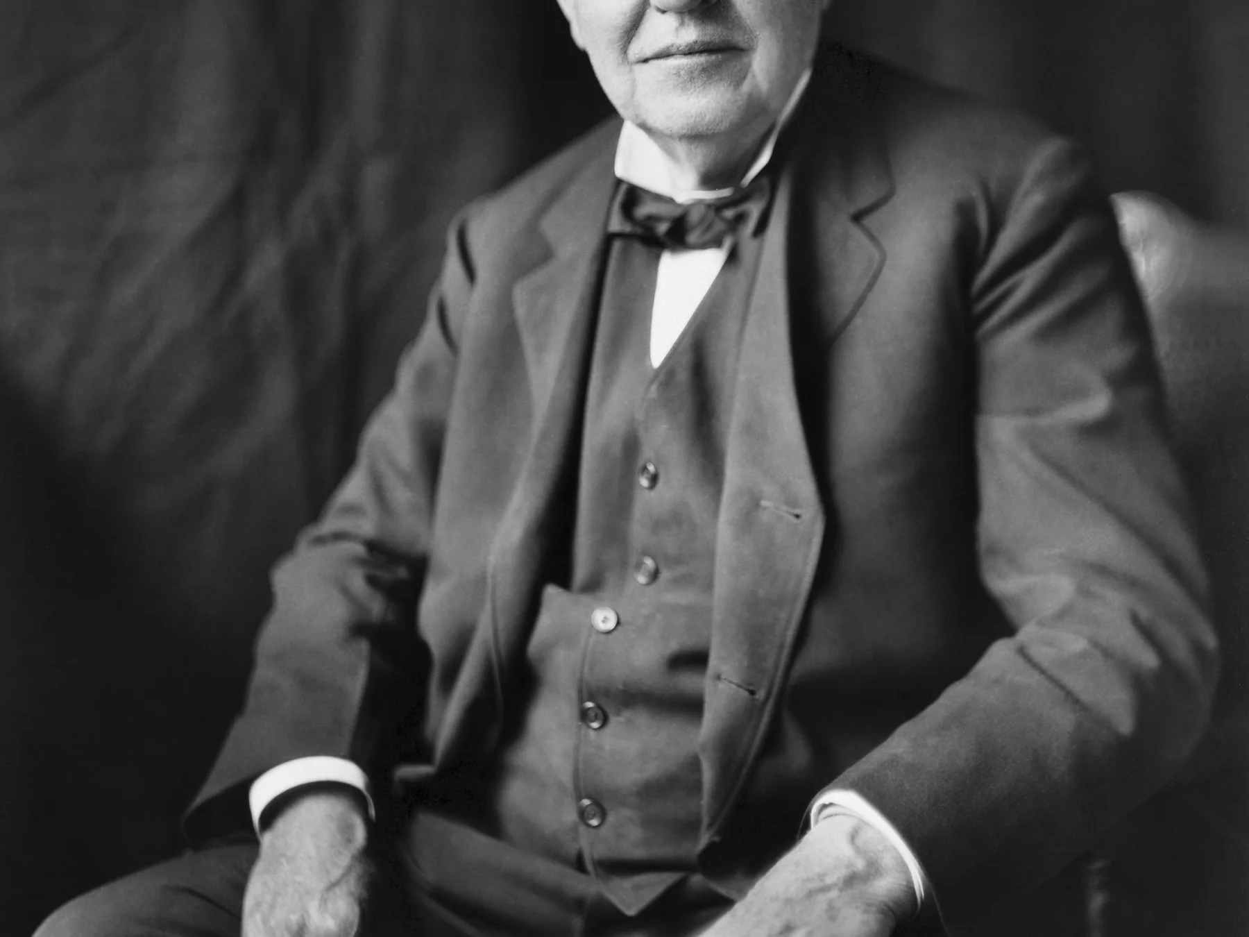 Thomas Edison seated in a dark suit