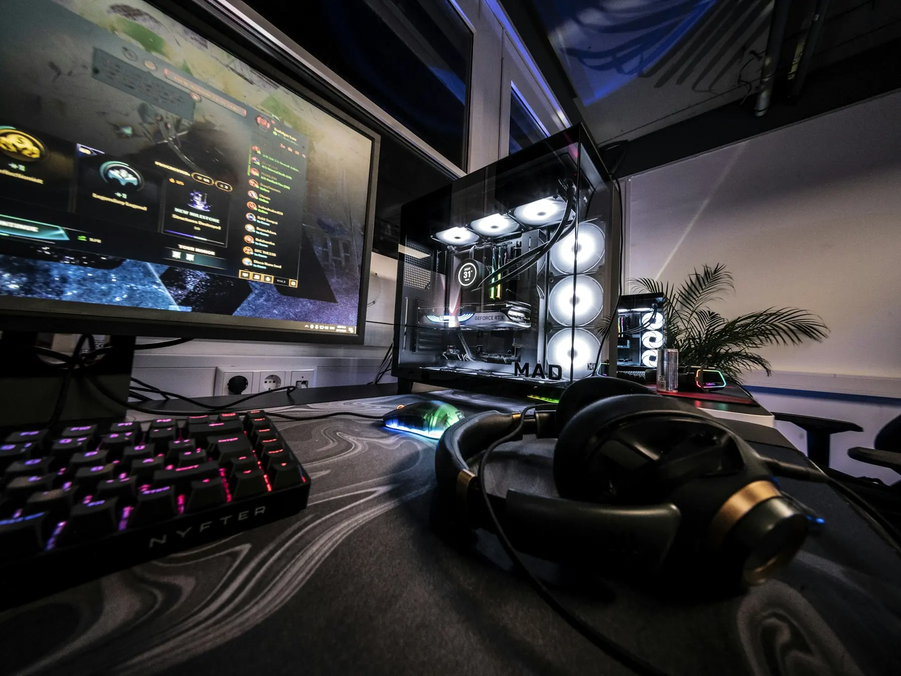 Gaming computer, monitor, keyboard, and steering wheel on a desk
