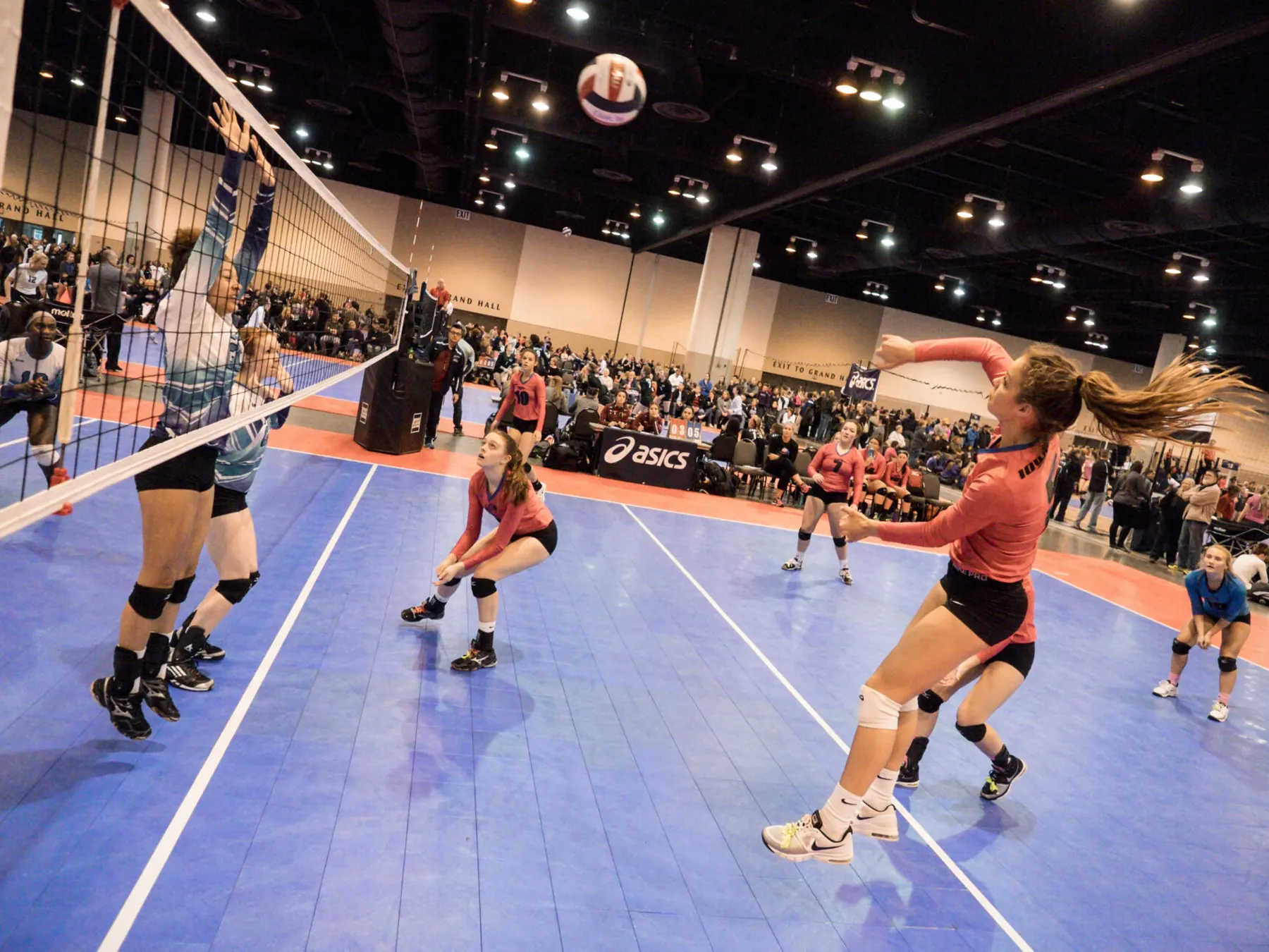 Women's volleyball match on an indoor court