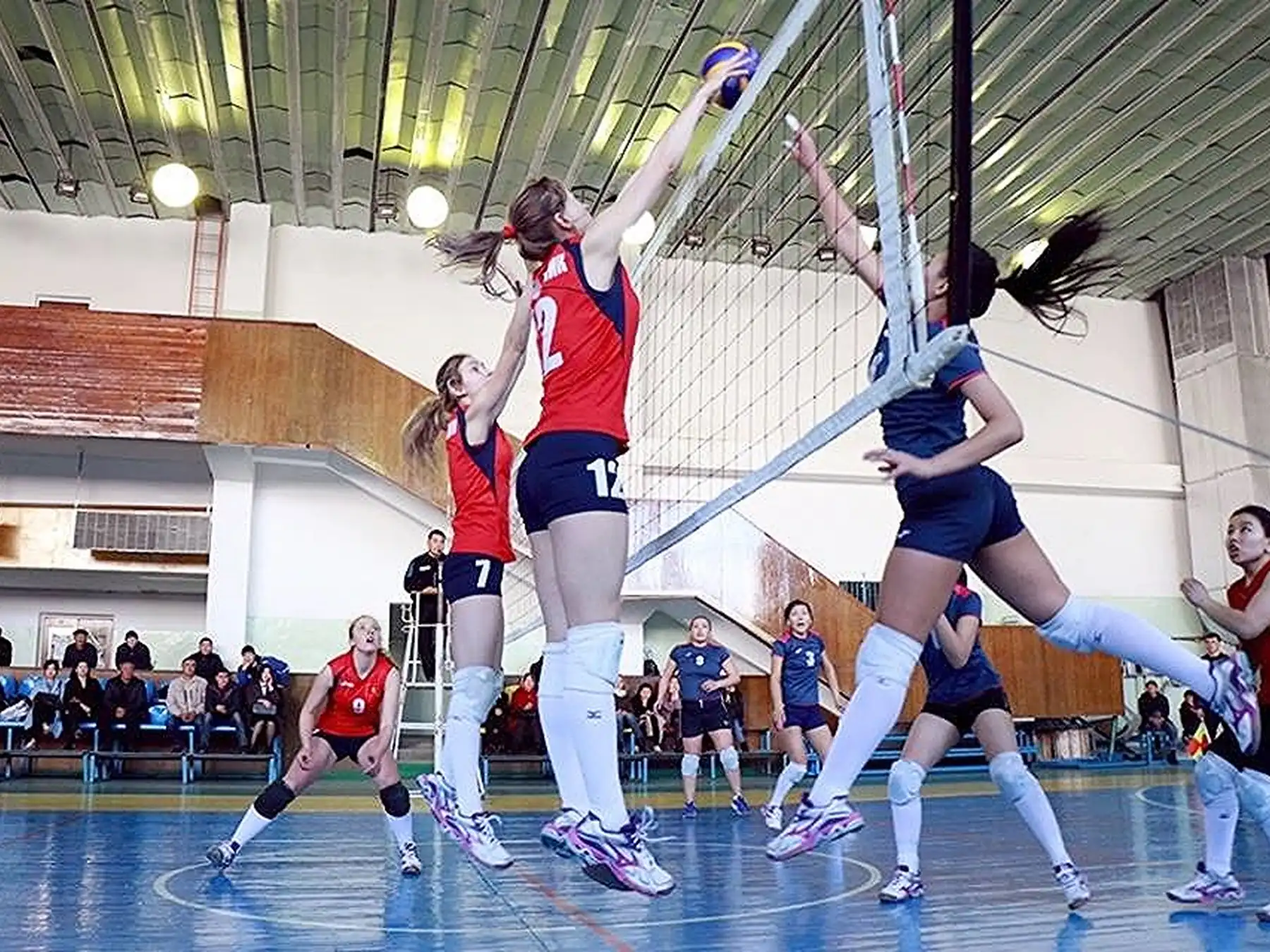 Players jumping at the net during a volleyball match