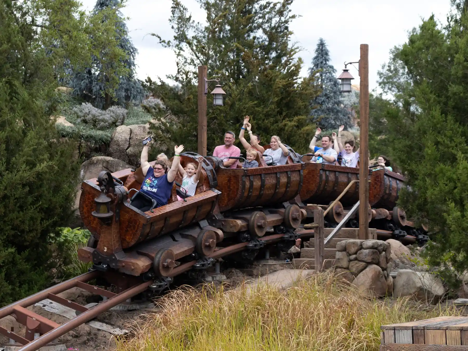 Guests riding a mine train roller coaster at a Disney theme park