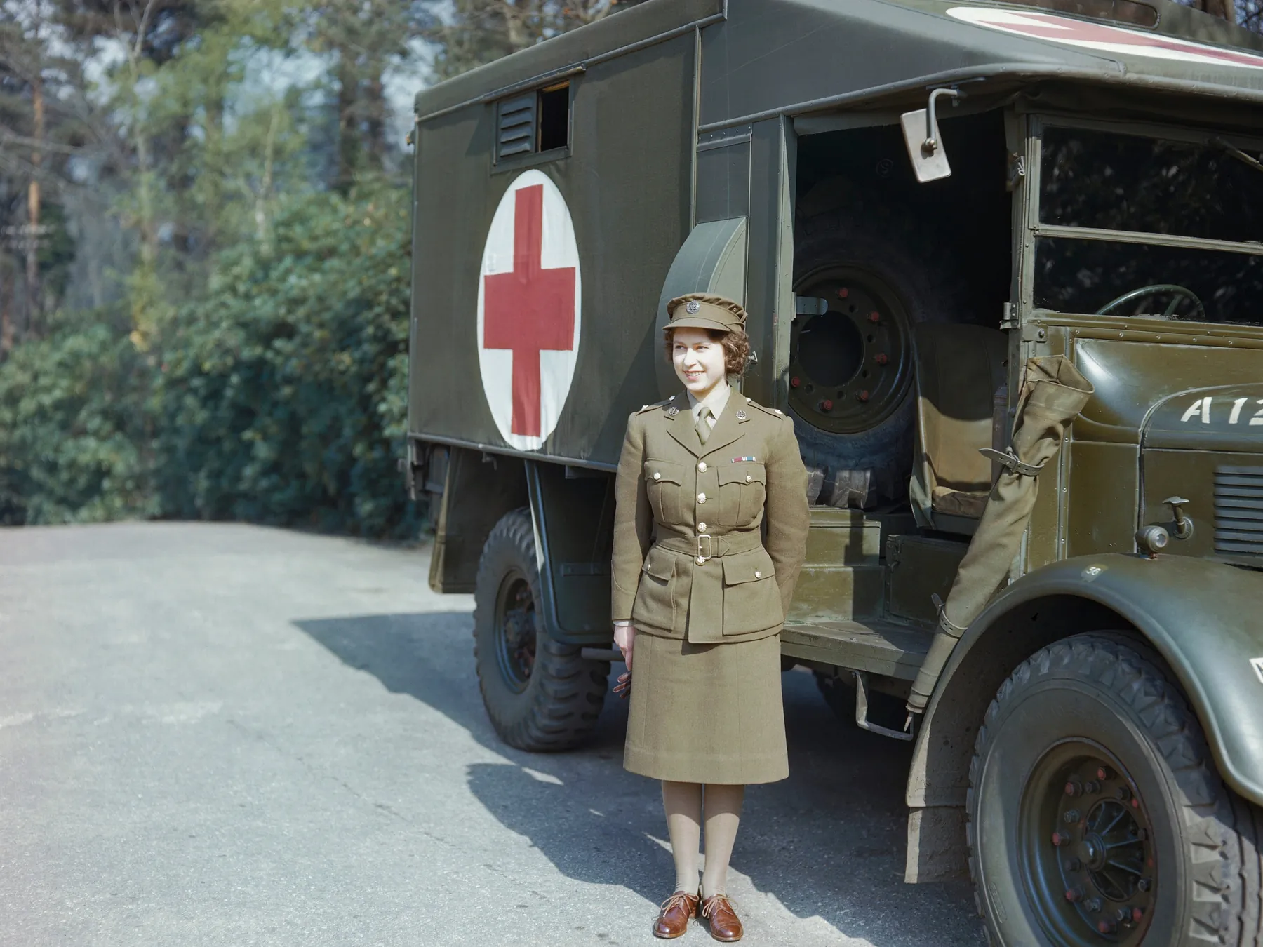 Princess Elizabeth in Auxiliary Territorial Service uniform beside a military ambulance in 1945
