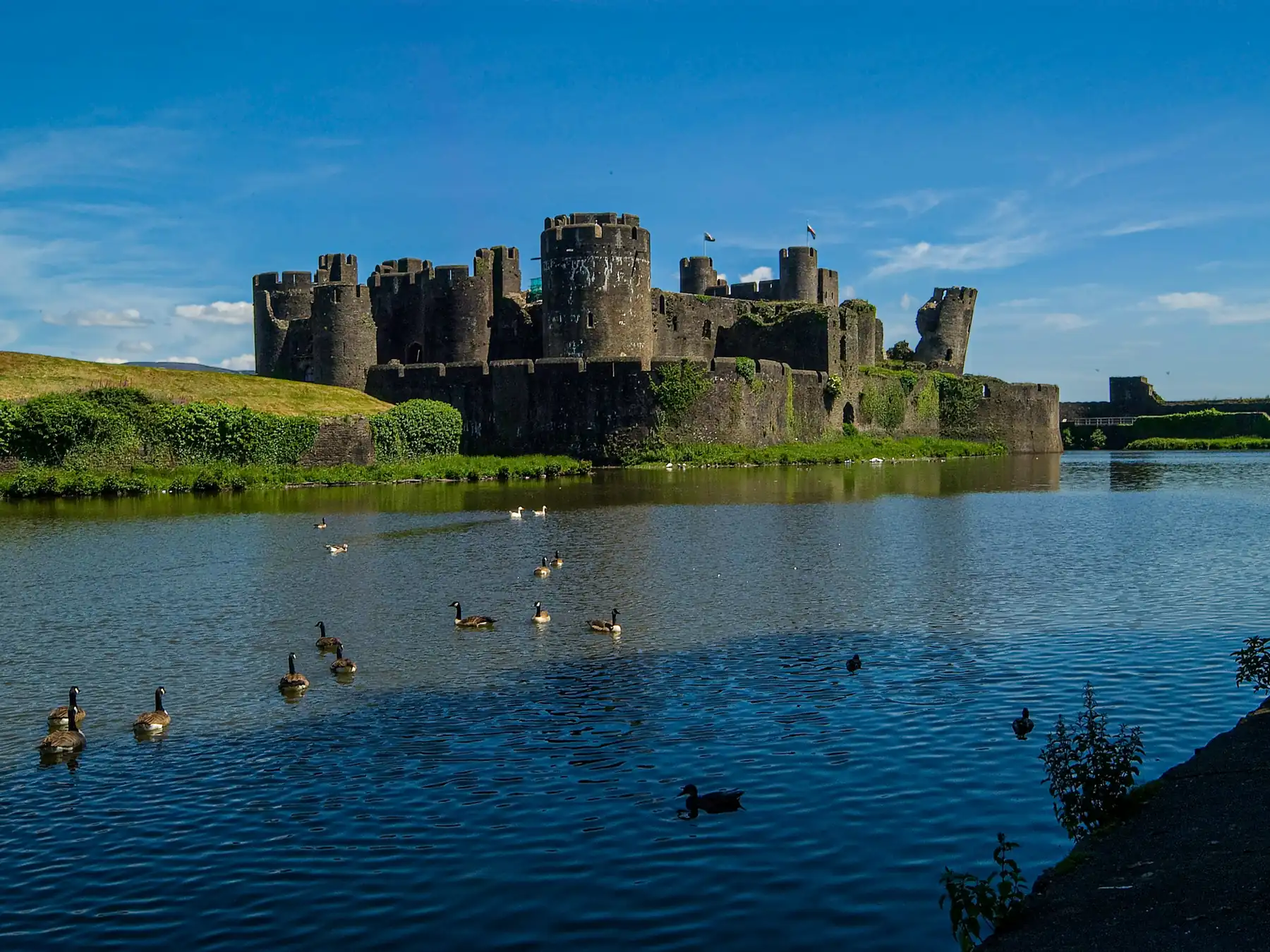 Medieval Caerphilly Castle reflected across its moat in Wales