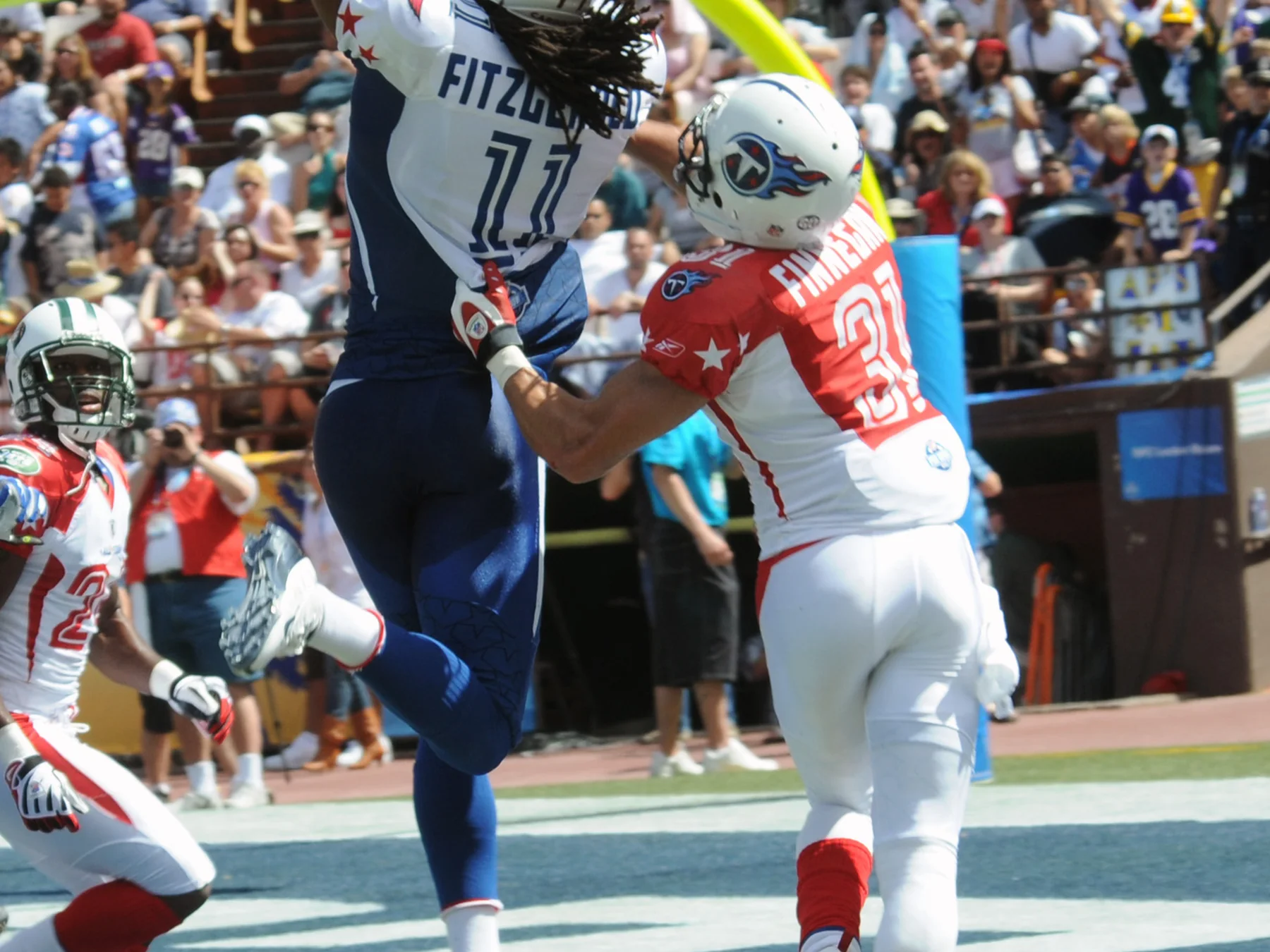 NFL players leaping to contest a pass during a game