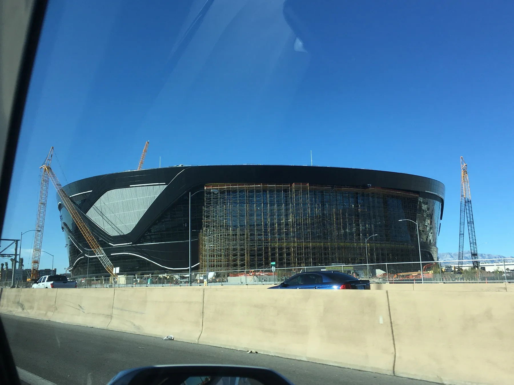 Large NFL stadium under construction beneath a blue sky
