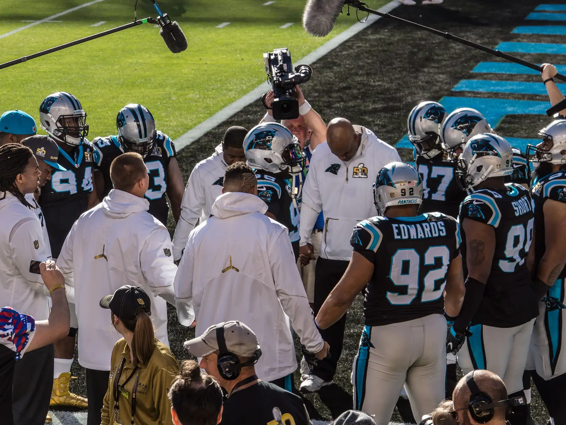 NFL players and coaches gathered on the sideline