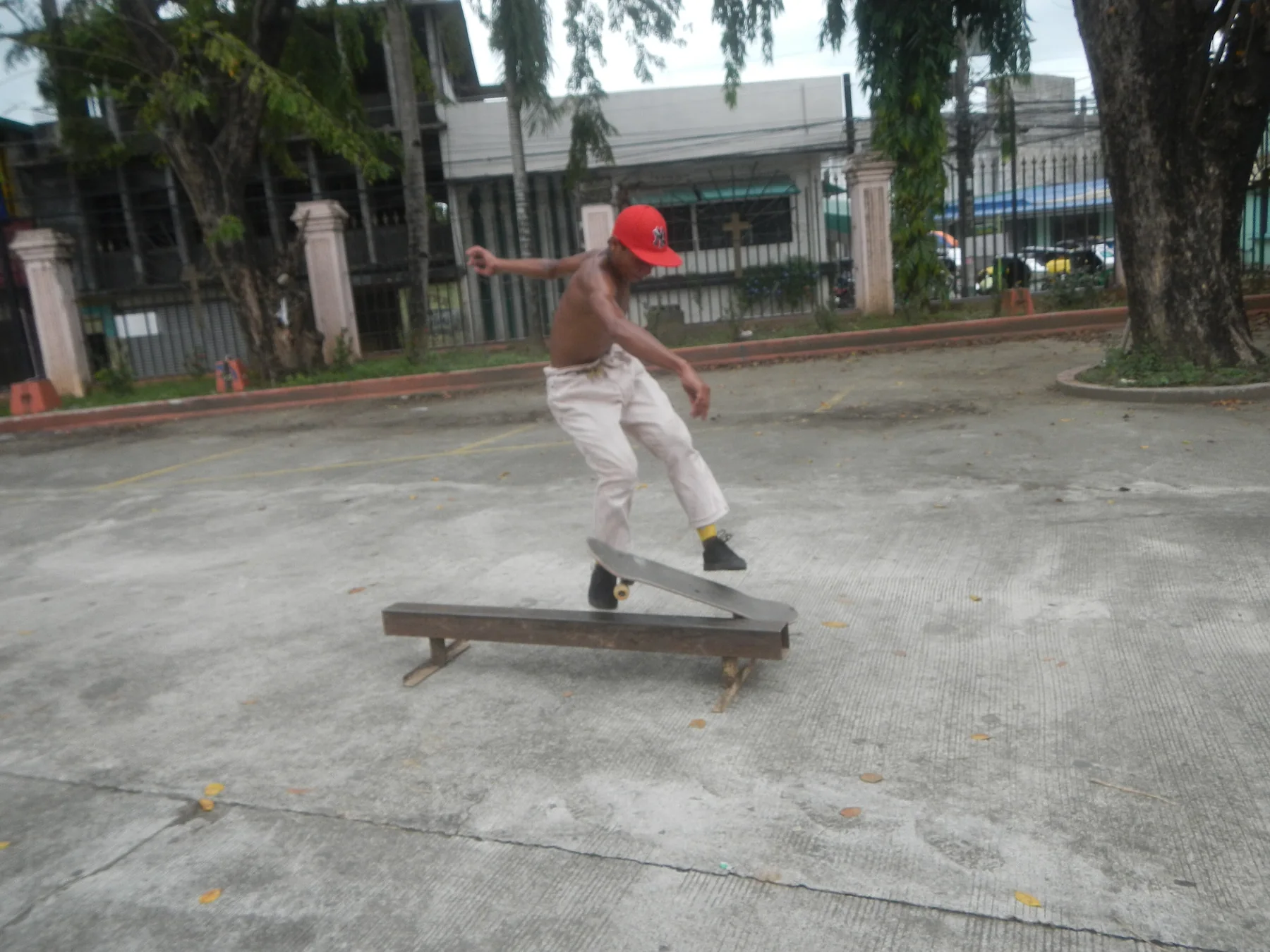 Skateboarder performing a trick over a low rail
