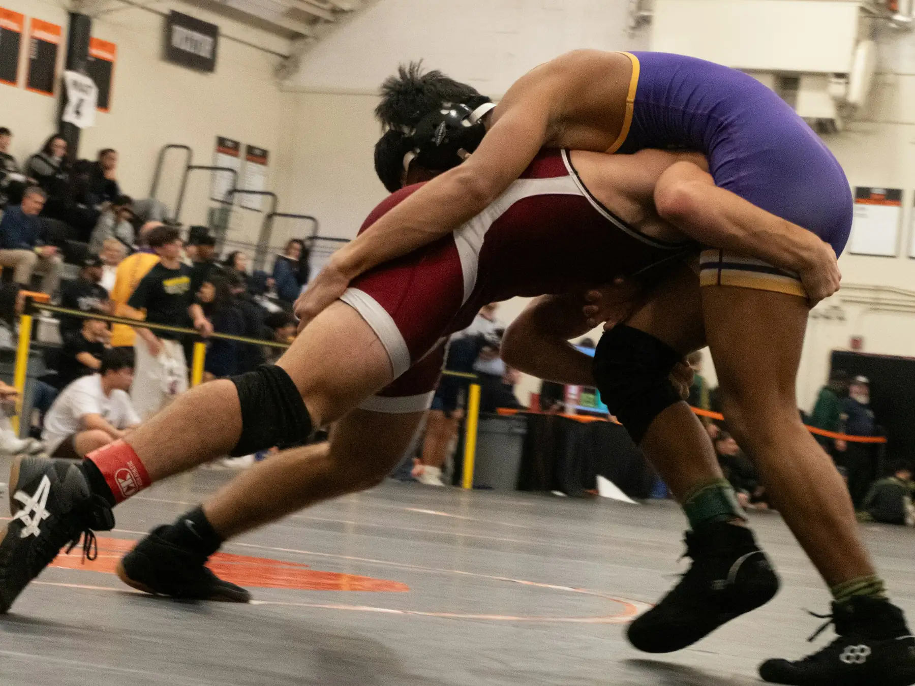 Two wrestlers competing on a wrestling mat